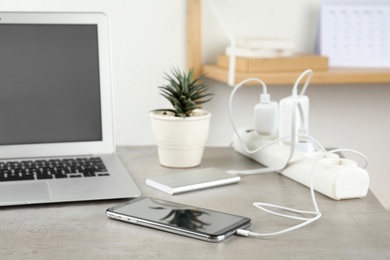 Photo of Devices charging with cable on light stone table