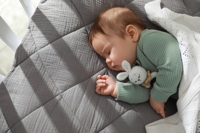 Cute little baby sleeping in crib at home. Space for text