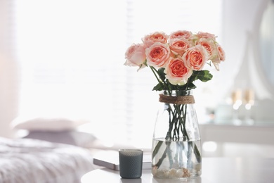Glass vase with beautiful flowers on table in modern room interior, space for text