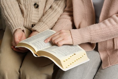 Women reading Bible together, closeup. Religious literature