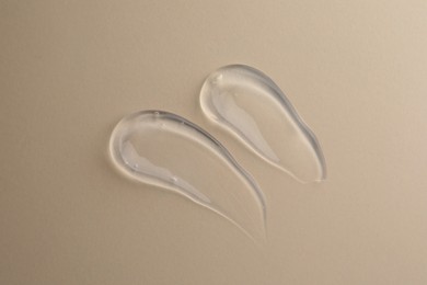Sample of transparent gel on beige background, top view