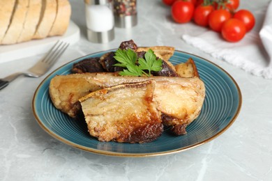 Photo of Tasty fried pork lard with parsley on light table