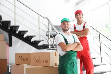 Portrait of male movers in uniform indoors