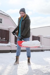 Young man shoveling snow outdoors on winter day