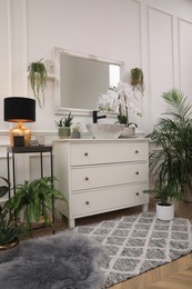 Stylish bathroom interior with modern furniture and beautiful houseplants