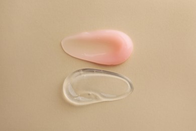 Samples of cosmetic gels on beige background, top view