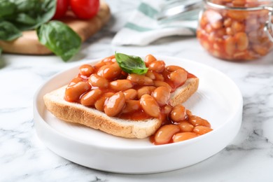 Toast with delicious canned beans on white marble table