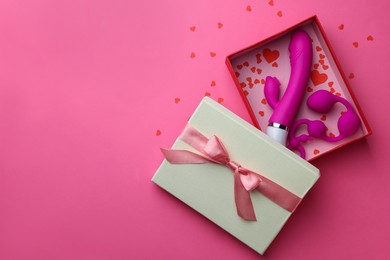 Gift box with sex toys on pink background, top view. Space for text