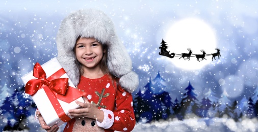 Cute little child and Santa Claus flying in his sleigh against moon sky on background. Christmas celebration