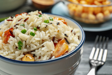 Delicious rice pilaf with chicken in bowl, closeup