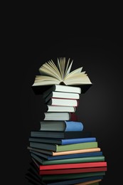 Photo of Stack of different hardcover books on black background