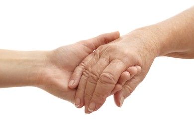Young and elderly women holding hands together on white background, closeup
