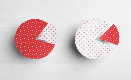 Circles with segments on white wooden background, flat lay. Pareto principle concept
