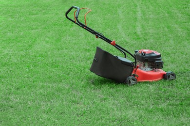 Modern garden lawn mower on green grass outdoors