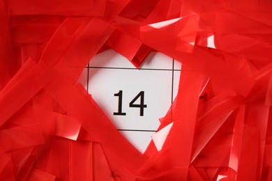 Red confetti on calendar with number 14, closeup. Valentine's Day celebration