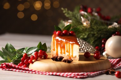 Tasty caramel cheesecake and Christmas decorations on wooden table, space for text