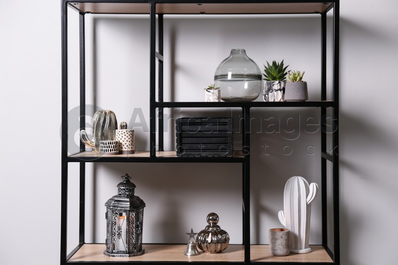Photo of Shelving with different decor and houseplants near white wall. Interior design