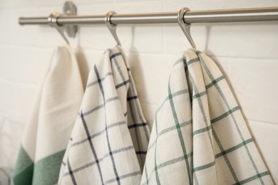 Different kitchen towels hanging on rack, closeup