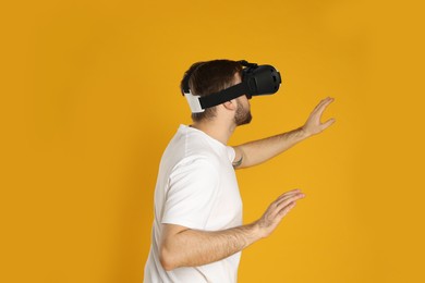 Man using virtual reality headset on yellow background