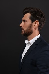 Profile portrait of handsome bearded man on black background