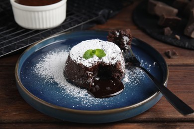 Delicious fresh fondant with hot chocolate and mint on wooden table