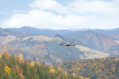 Modern drone flying in mountains on autumn day