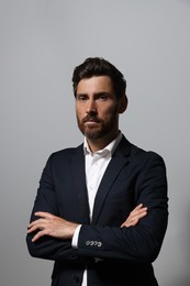 Portrait of handsome bearded man in suit on light grey background