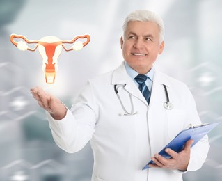 Senior doctor demonstrating virtual icon with illustration of female reproductive system on light background. Gynecological care 