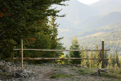 Country road with wooden fence near forest in mountains
