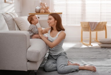 Photo of Young woman with her little baby at home