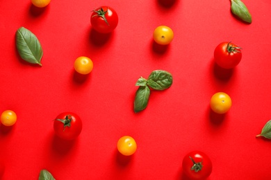 Flat lay composition with ripe cherry tomatoes and basil leaves on color background