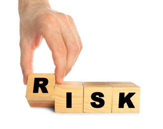 Man making word Risk of wooden cubes on white background, closeup