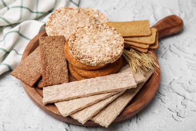 Rye crispbreads, rice cakes and rusks on white textured table