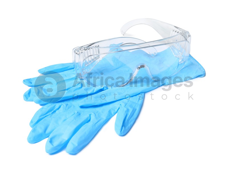 Medical gloves and safety glasses on white background