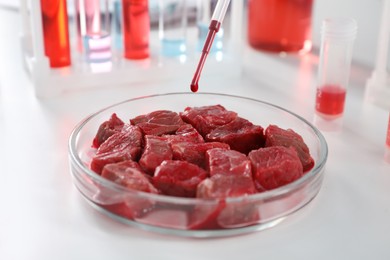 Photo of Dripping sample onto raw cultured meat on white table in laboratory, closeup