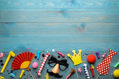 Flat lay composition with carnival items on light blue wooden background. Space for text