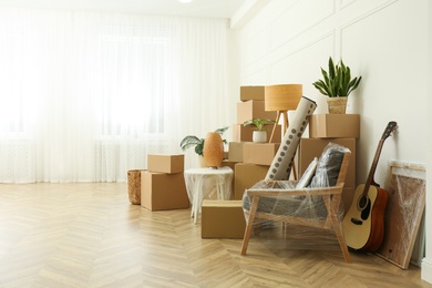 Photo of Cardboard boxes and household stuff indoors, space for text. Moving day