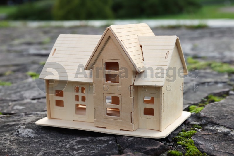 House model on stone road with cracks. Earthquake disaster
