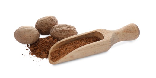 Wooden scoop with nutmeg powder and seeds on white background