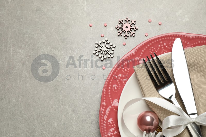 Festive table setting with beautiful dishware and Christmas decor on grey background, flat lay. Space for text