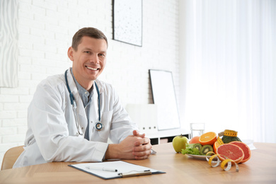 Nutritionist with clipboard at desk in office