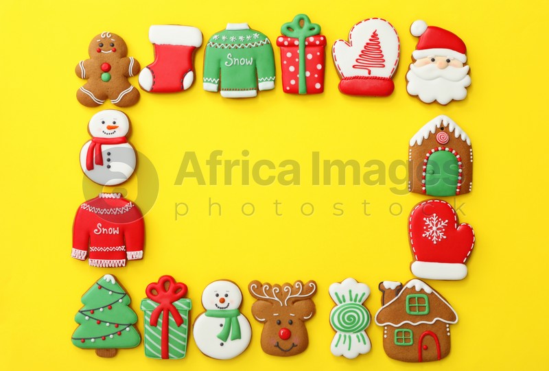Frame made with different Christmas gingerbread cookies on yellow background, flat lay. Space for text