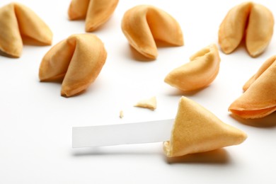Tasty fortune cookies with predictions on white background, closeup. Space for text