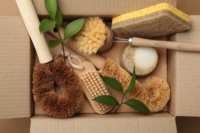 Cardboard box with eco friendly products on craft paper, top view