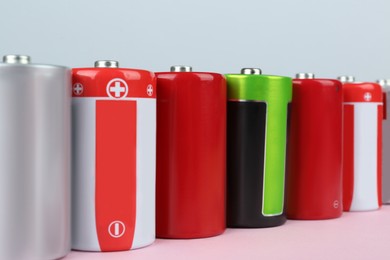 Many new D batteries on color background, closeup