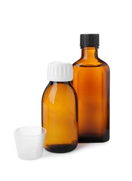 Bottles of syrups with measuring cup on white background. Cough and cold medicine
