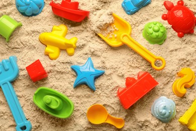 Beach toy kit on sand, flat lay. Outdoor play