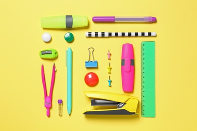 Photo of Flat lay composition with different school stationery on yellow background
