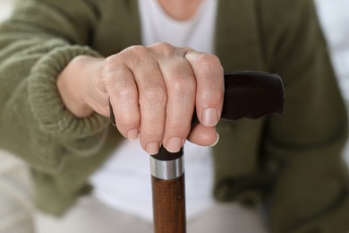 Elderly woman with walking cane indoors, closeup. Home care service