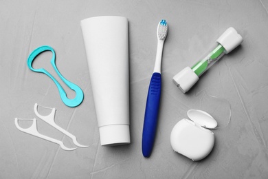 Flat lay composition with tongue cleaner and teeth care products on grey background